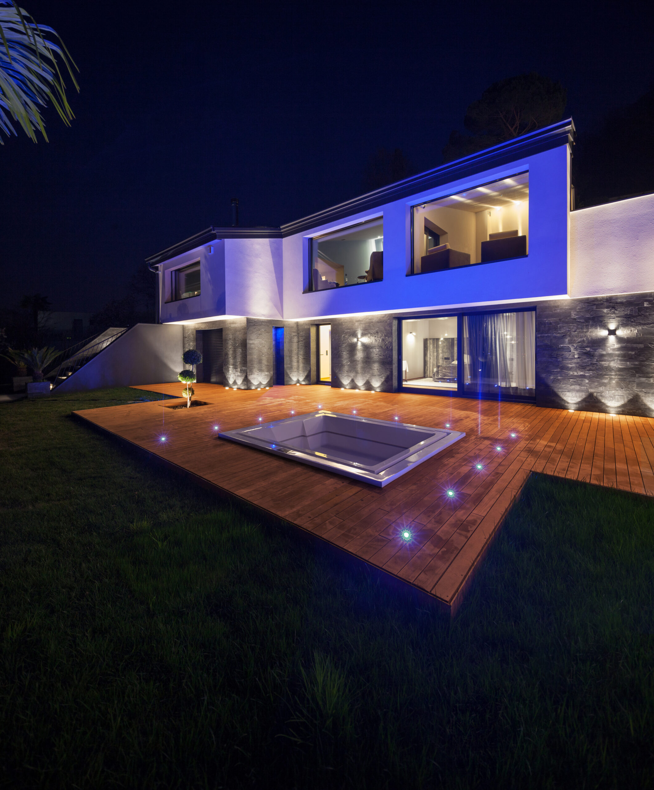 View of modern villa with pool in the night using permament lights