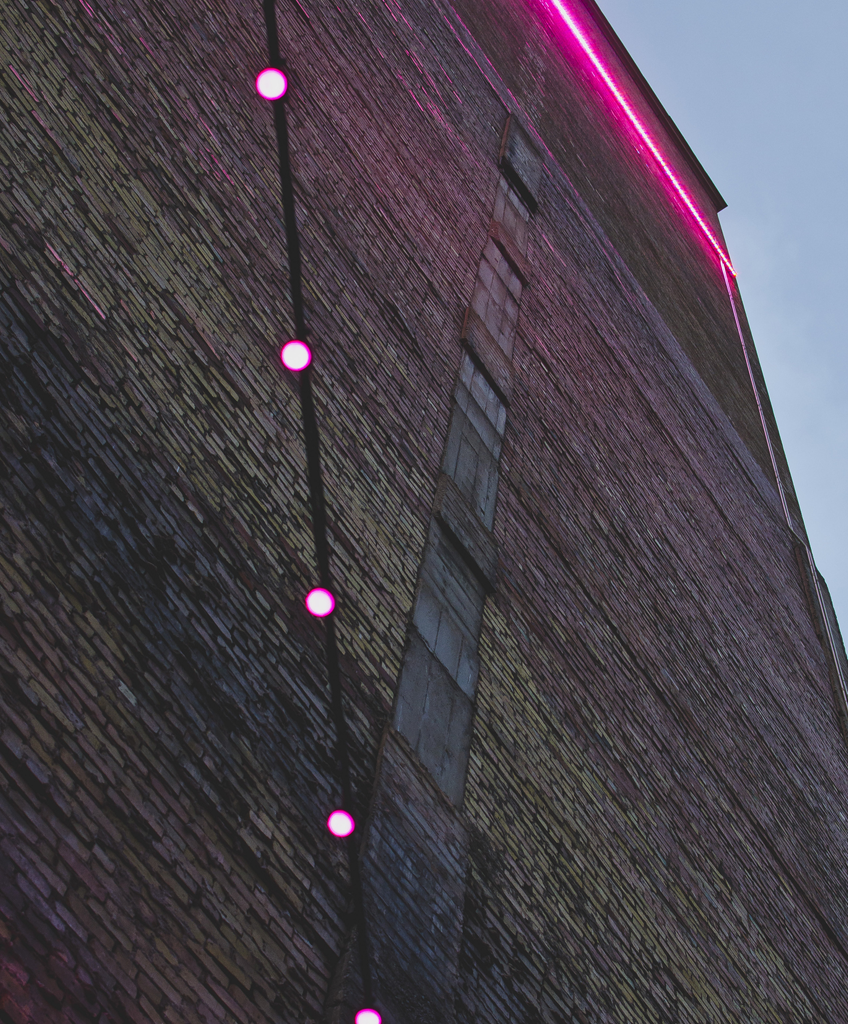 Pink light along the brick wall
